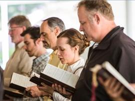 Staff members singing along with another from hymns.